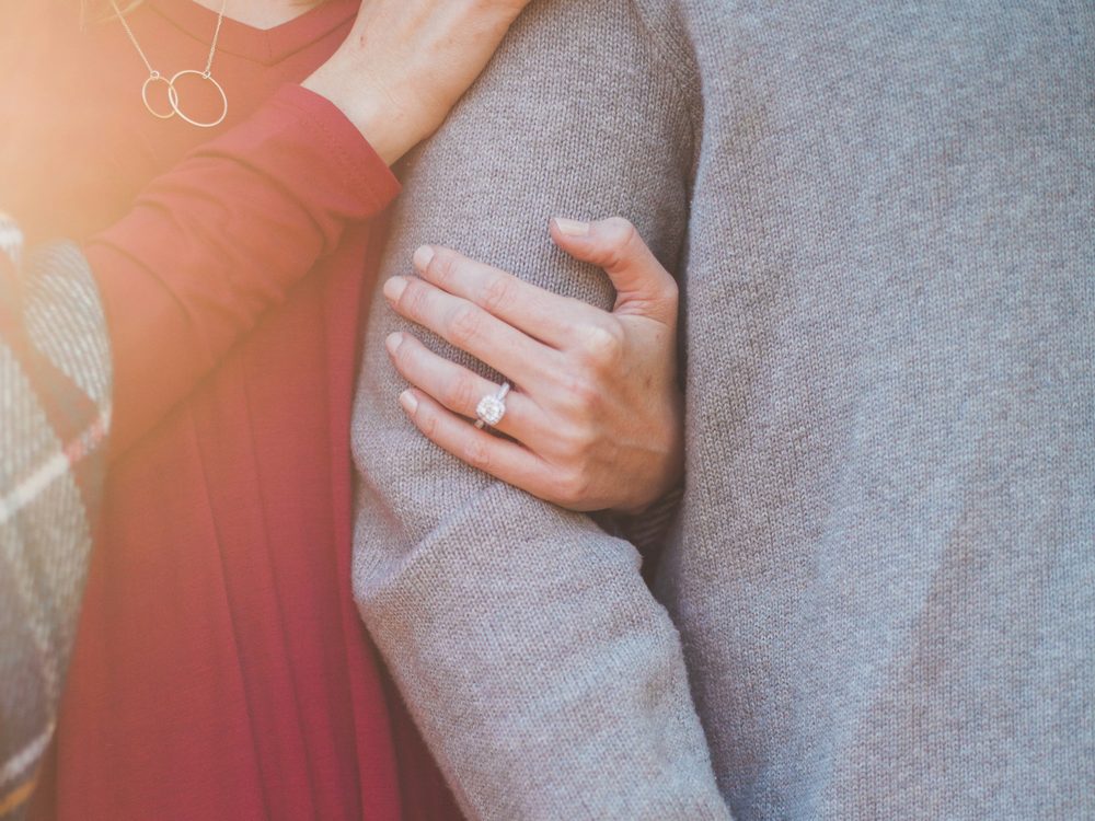 A happily engaged couple, her hand resting on his arm